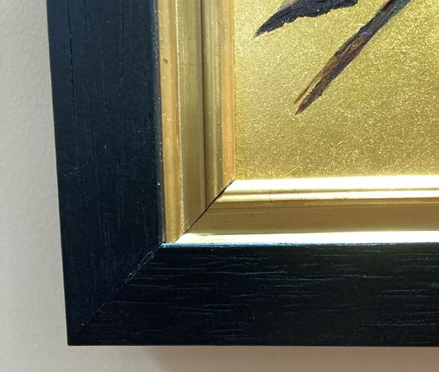 A photograph of part of a painting of a Hummingbird on gold leaf showing the detail of the frame