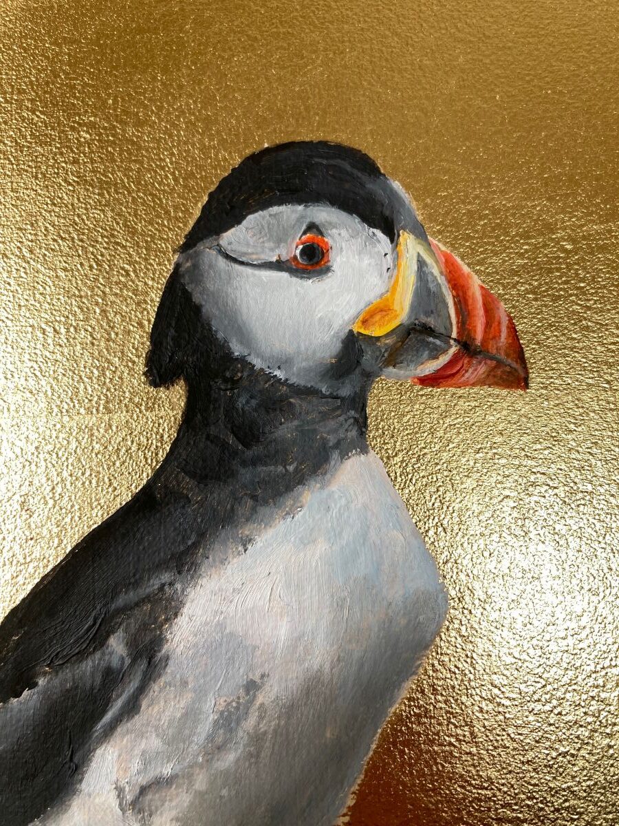 Close up of a fine art oil painting of a puffin on a background of gold leaf