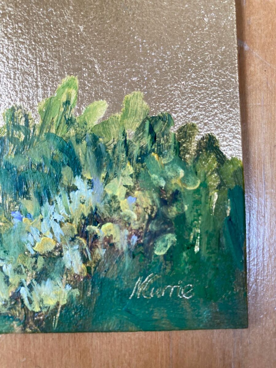 Close up of Nicola Currie's signature in the bottom right hand corner of a painting on green with gold leaf above